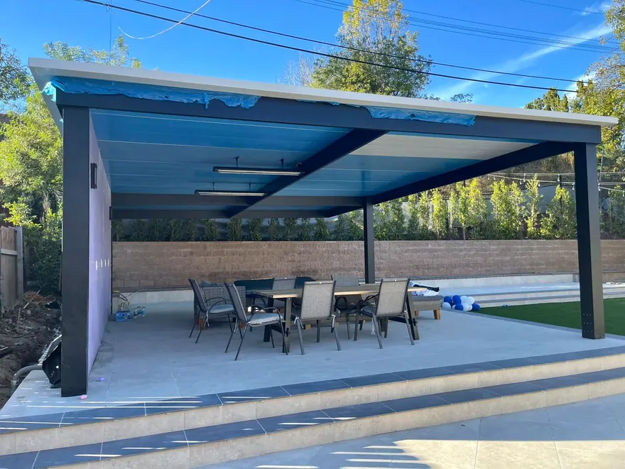 Custom outdoor metal patio structure beside swimming pool