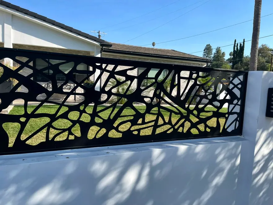 Organic-pattern metal railing along a modern residential property